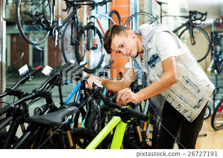Boy looking for and trying new racing bicycle 26727191