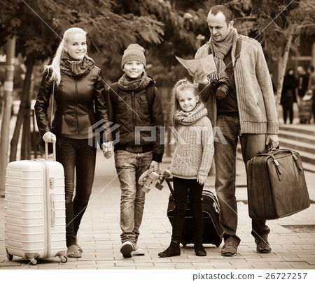 Parents with two kids and baggage with map . 26727257