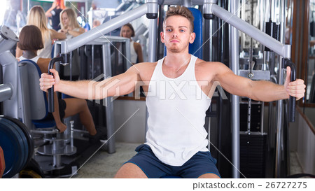 Young man using fly machine in gym. Young man using fly machine in gym. 26727275