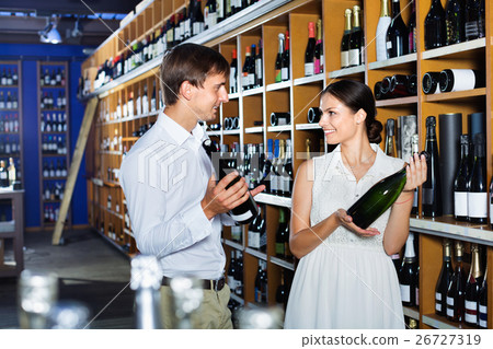 Portrait of male and female customers picking bottle of wine Portrait of male and female customers picking bottle of wine 26727319