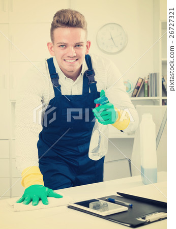 Handsome guy in uniform cleaning in office 26727321