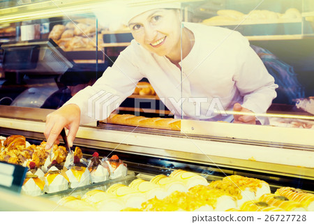 Portrait of baker with sweet cakes in local confectionery 26727728