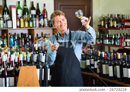 Man working in wine house holding glass of wine for tasting Man working in wine house holding glass of wine for tasting 26728226
