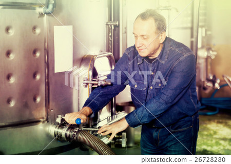 Elderly worker checks equipment on winery Elderly worker checks equipment on winery 26728280