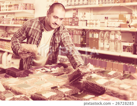Male customer choosing nuts and grain in average food shop Male customer choosing nuts and grain in average food shop 26728283