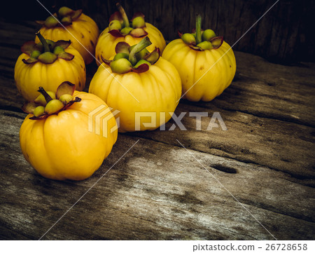 Garcinia cambogia fresh fruit on wood background. Garcinia cambogia fresh fruit on wood background. 26728658