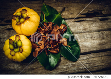 Garcinia cambogia fresh fruit on wood background. Garcinia cambogia fresh fruit on wood background. 26728660