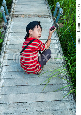 Back view of tired asian boy relaxing outdoors 26728755