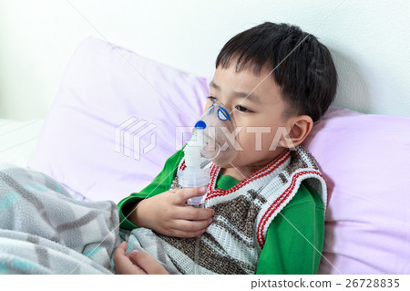 Closeup of asian child holds a mask vapor inhaler. Closeup of asian child holds a mask vapor inhaler. 26728835