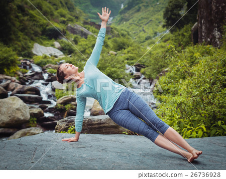 Woman doing yoga asana Vasisthasana - side plank Woman doing yoga asana Vasisthasana - side plank 26736928