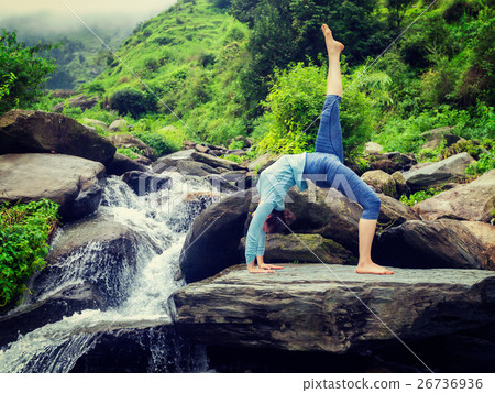Woman doing yoga asana at waterfall 26736936