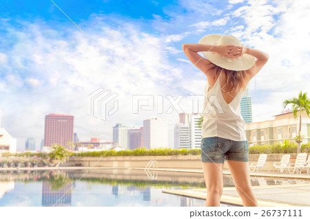 Young woman enjoying her vacation beside the pool Young woman enjoying her vacation beside the pool 26737111