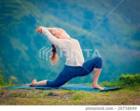 Sporty fit woman practices yoga asana Anjaneyasana 26738649