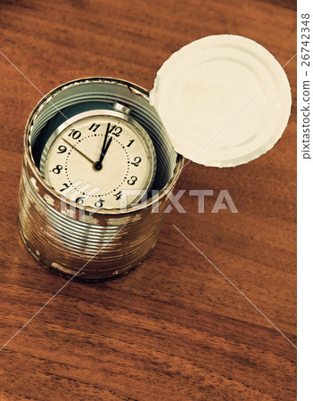 Time preserved in tin can on wooden table. Time preserved in tin can on wooden table. 26742348