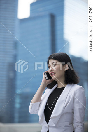 Asian businesswoman talking on smart phone. Asian businesswoman talking on smart phone. 26747404