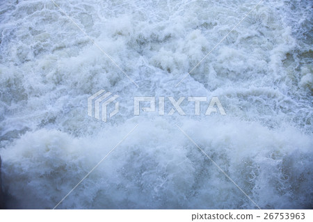 Water flowing from the open sluice gates of dam. 26753963