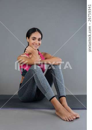 Attractive sportswoman smiling while looking at 26759341