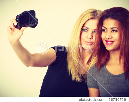 Two models girls taking self picture with camera Two models girls taking self picture with camera 26759736