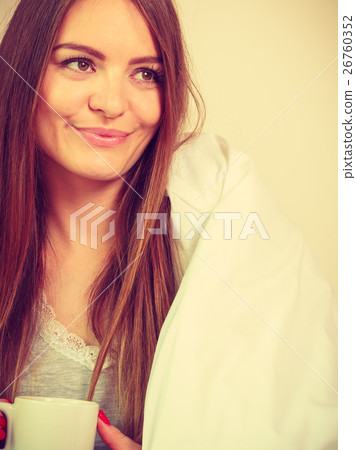 Smiling woman holding cup of drink in bed Smiling woman holding cup of drink in bed 26760352