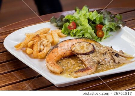 Salmon steak with lemon sour sauce on table  26761817