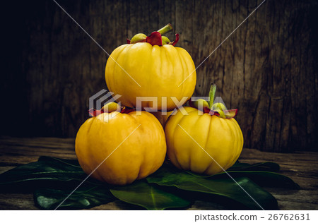 Garcinia cambogia fresh fruit on wood background. 26762631