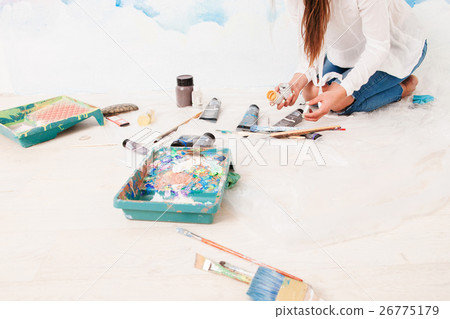 Artist sitting on floor with tools, free space 26775179