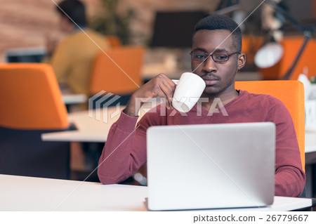 Cheerful young African businessman typing looking 26779667