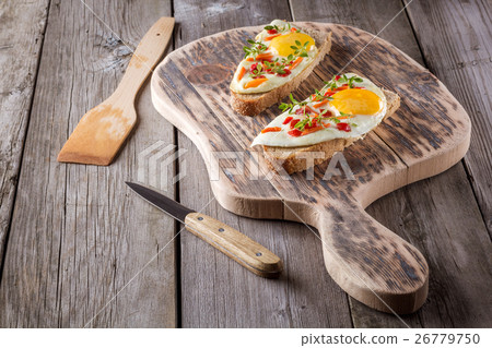 scrambled eggs with bread on cutting board 26779750