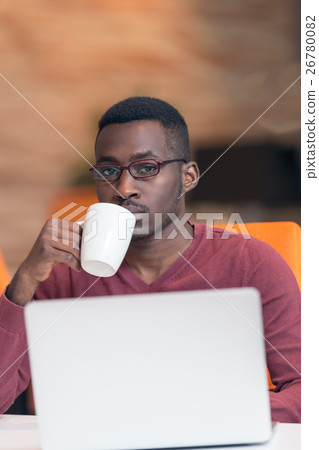 Cheerful young African businessman typing looking 26780082