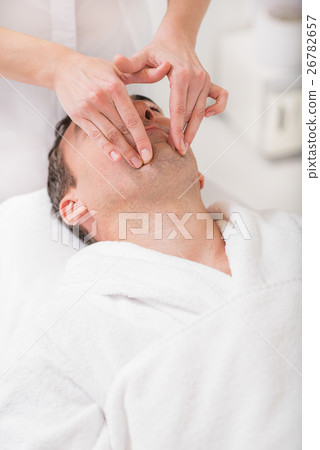 Masseuse massaging male face at spa Masseuse massaging male face at spa 26782657