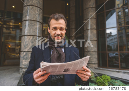 Man is satisfied with information in newspaper 26783478