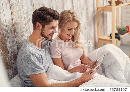 Happy man and woman with computer in bedroom Happy man and woman with computer in bedroom 26785197