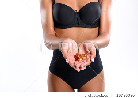 Young woman is holding pills Young woman is holding pills 26786080