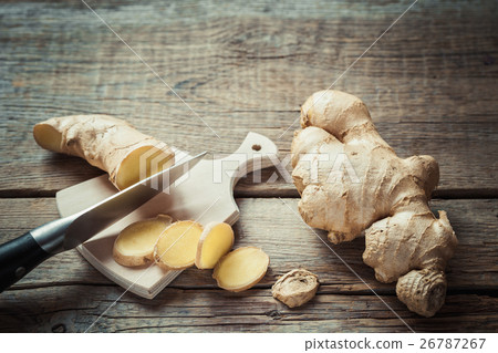 Ginger root on cutting board on kitchen table. Ginger root on cutting board on kitchen table. 26787267