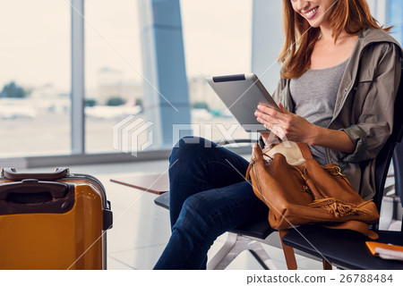 Beautiful girl using tablet in airport 26788484
