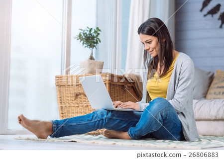 Positive woman using the laptop at home 26806883