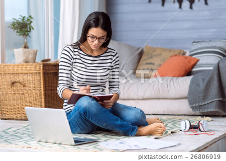 Involved young lady making notes in the bedroom 26806919