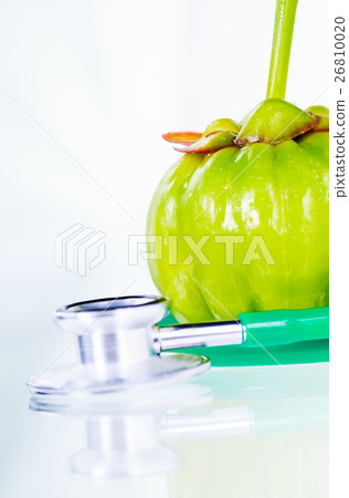 Closeup garcinia cambogia and stethoscope 26810020