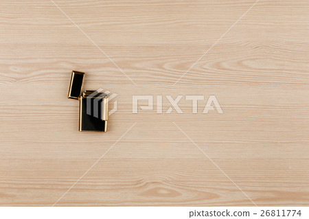 Luxury gold lighter lying on a wooden surface. Luxury gold lighter lying on a wooden surface. 26811774