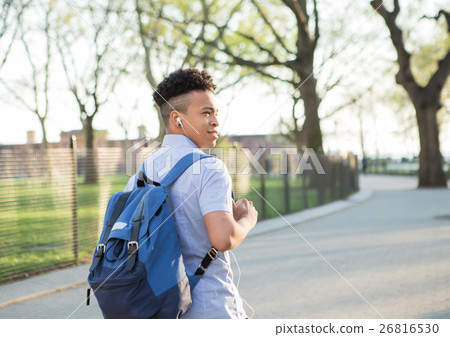 Young Hispanic boy with packpack walk on college campus 26816530