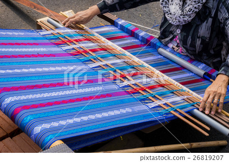 Hand of the woman weaves traditional fabric. Hand of the woman weaves traditional fabric. 26819207