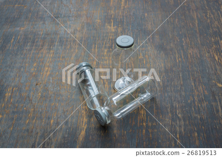 Mini empty bottles isolated on wood background. 26819513