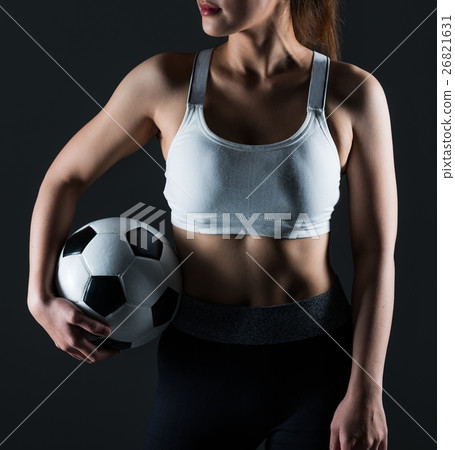 Beautiful woman holding a football gray background Beautiful woman holding a football gray background 26821631