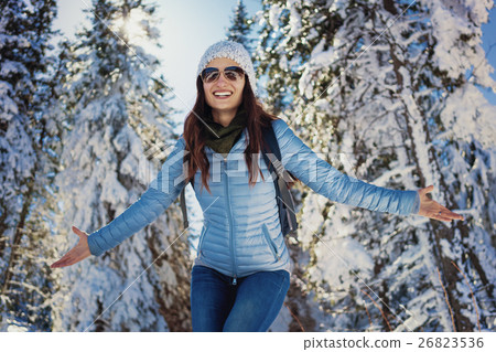 Woman having happy walk in snow covered woods 26823536