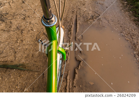 Bicycle ride through muddy dirt road Bicycle ride through muddy dirt road 26824209