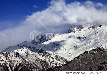 Snow mountains in clouds in winter sun day 26826710