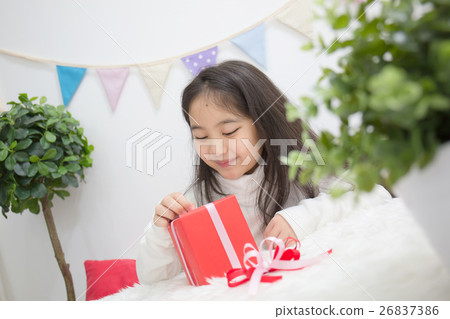 Happy Asian girl opening a present to guess whats 26837386