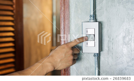 Man turning on or off on a light switch. Man turning on or off on a light switch. 26839683