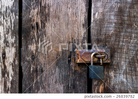 Old master key lock on old wooden background 26839782