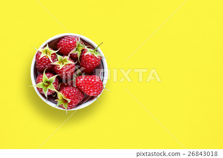 Raspberry in bowl on yellow table 26843018